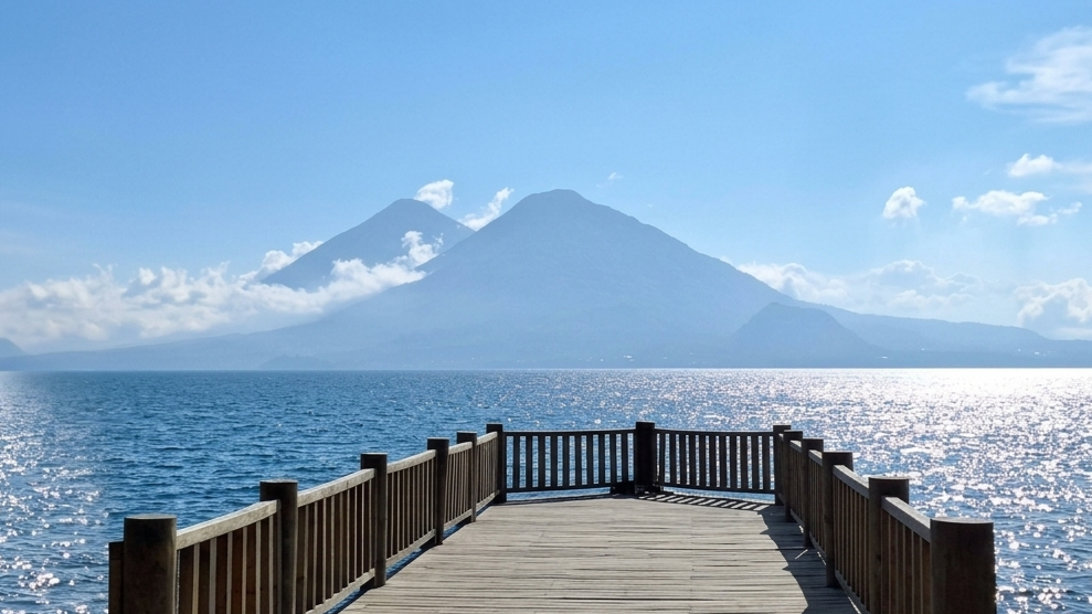 Three volcanoes mirrored in Lago Atitlán at sunrise
